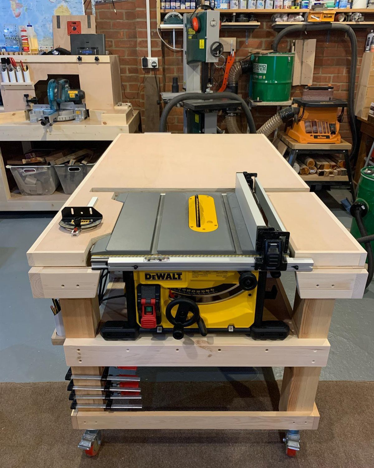 Table saw integrated into a wooden workbench with a large outfeed table surface.