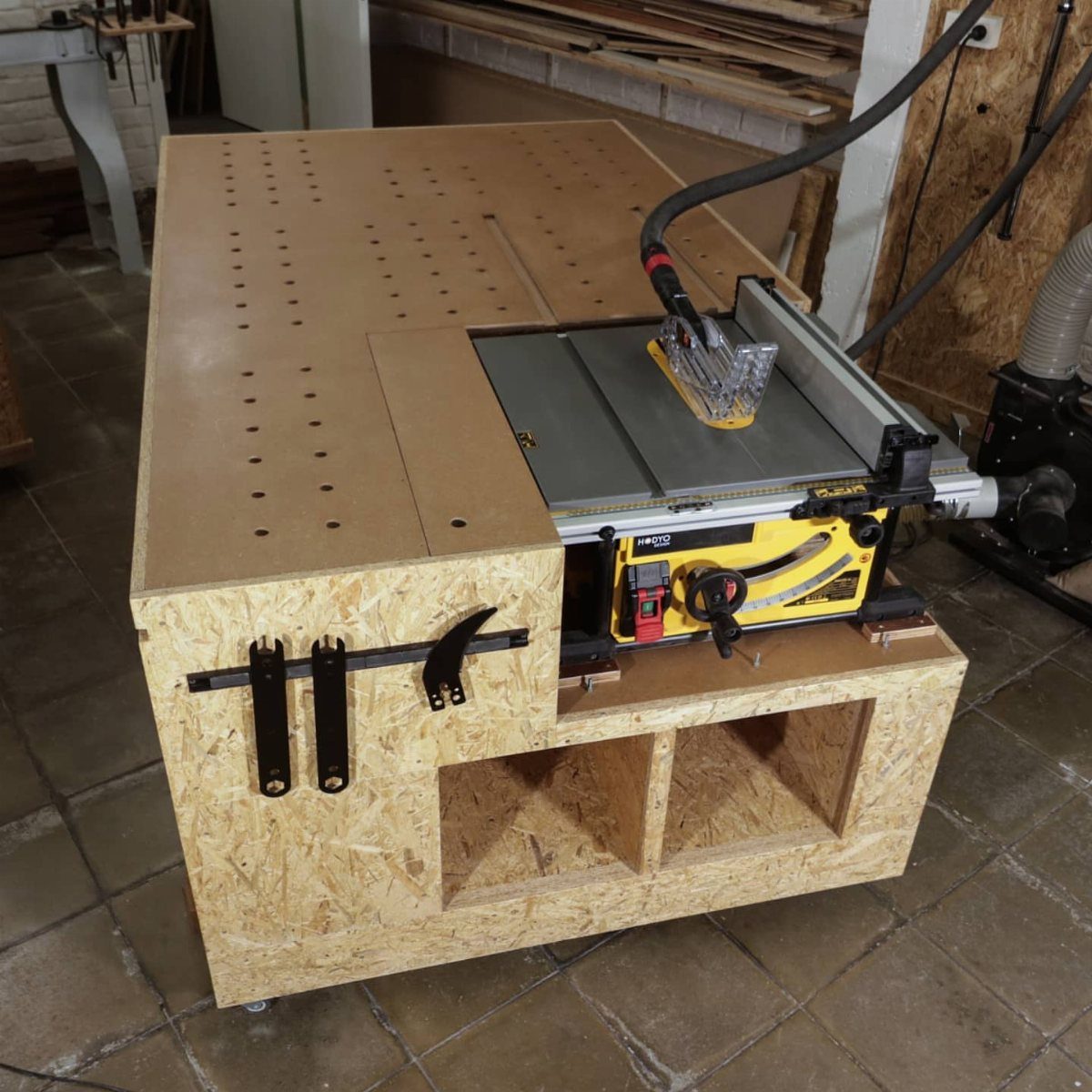 Table Saw Dust Collection: 5 Ideas for a Cleaner Shop 3 Table saw integrated into a custom OSB workbench with a vacuum dust collection hose.