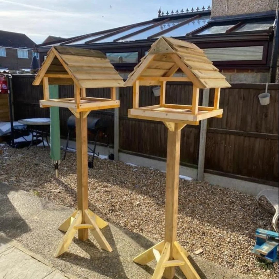 Table Saw Projects: 15 Ideas to Build This Weekend 3 Two wooden birdhouses on tall posts standing in a backyard near a fence.