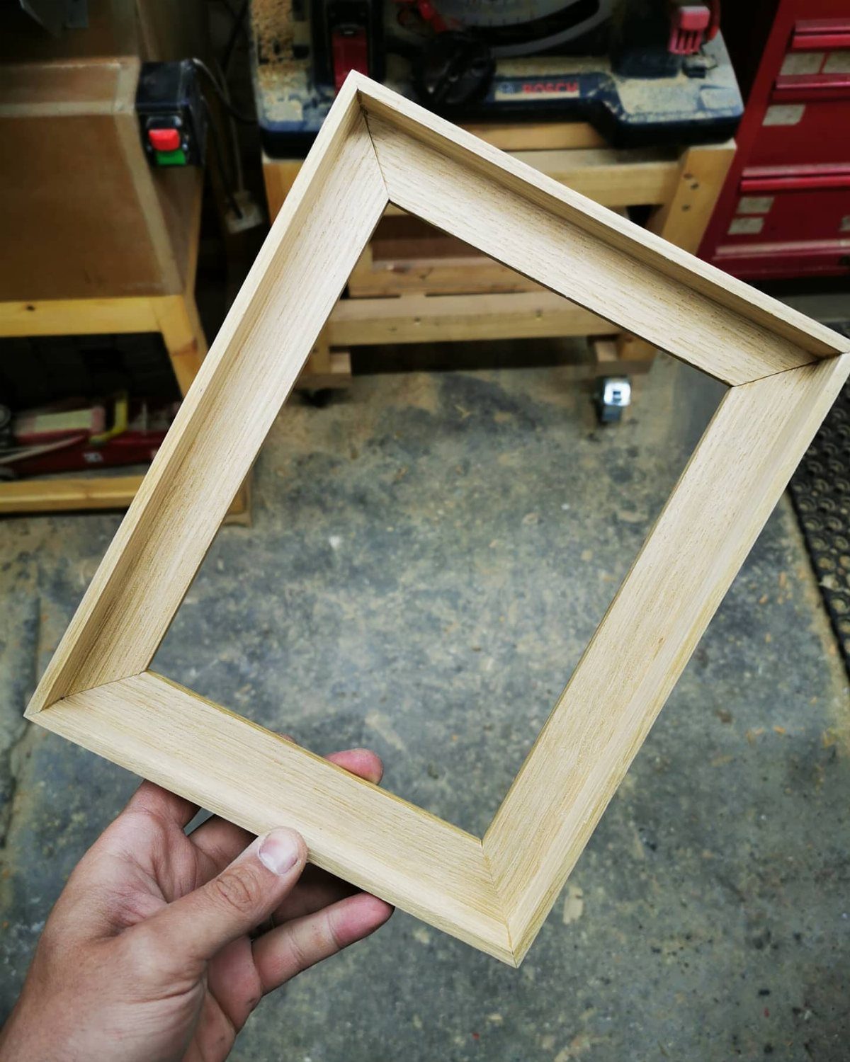 Table Saw Projects: 15 Ideas to Build This Weekend 5 Unfinished light wood picture frame held by a hand in a woodworking shop.
