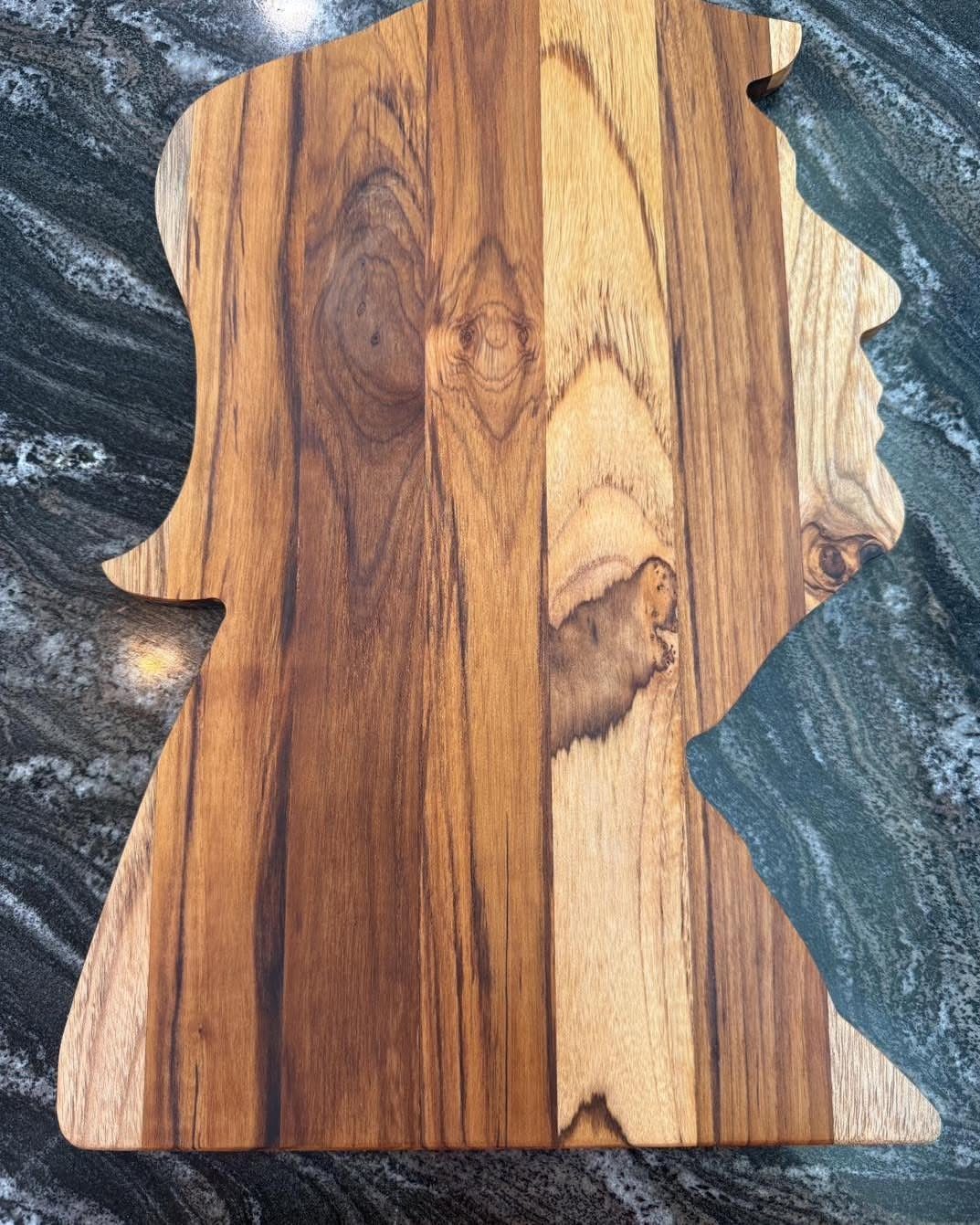 Table Saw Projects: 15 Ideas to Build This Weekend 12 Wooden cutting board shaped like a human profile on a marbled countertop.
