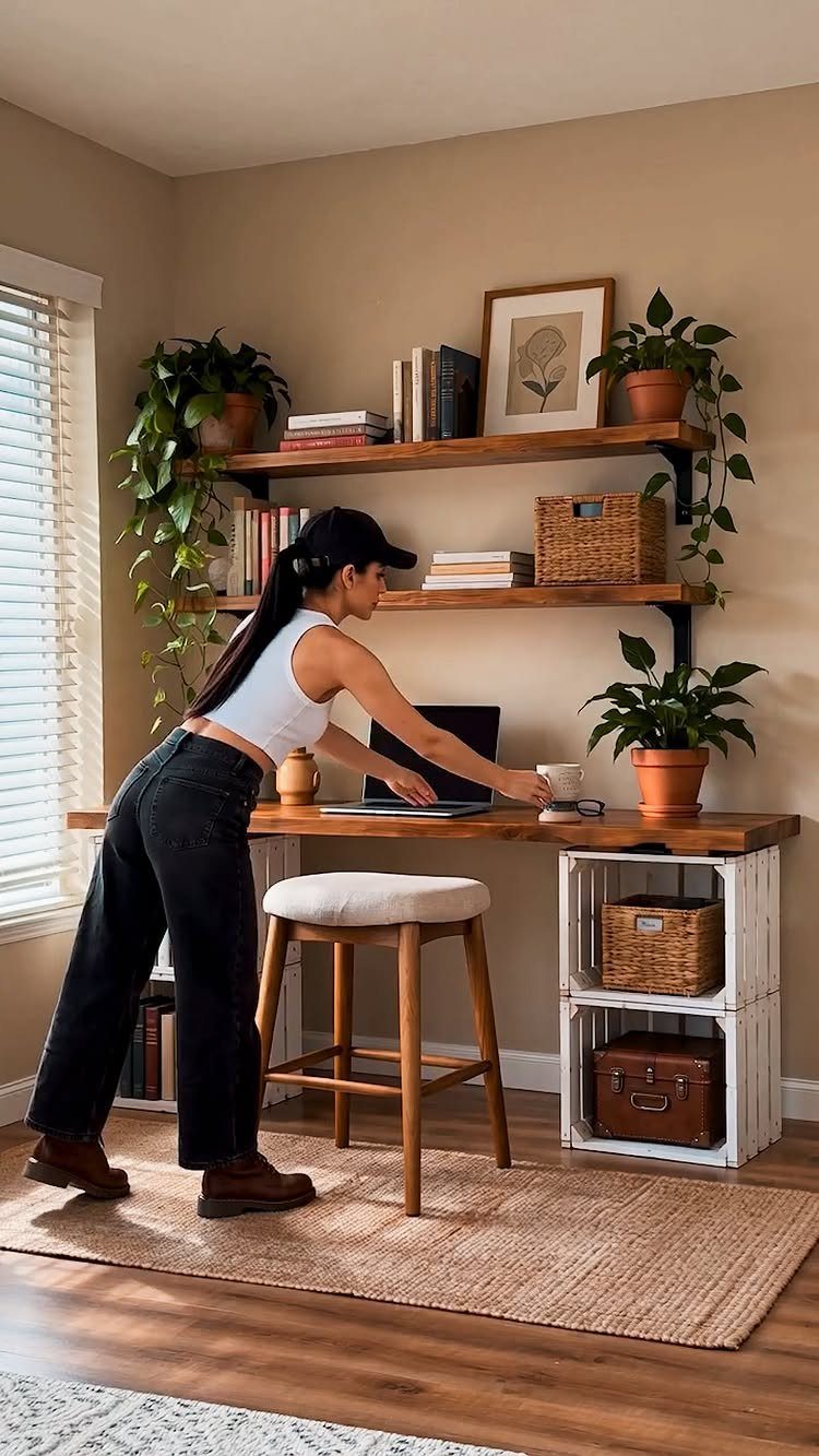 Woman working at a wooden desk with floating shelves and a stool.