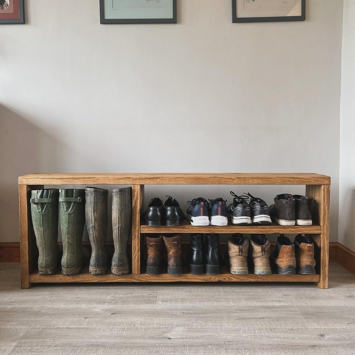 Wooden shoe cubby organizer holding boots and sneakers against a white wall.