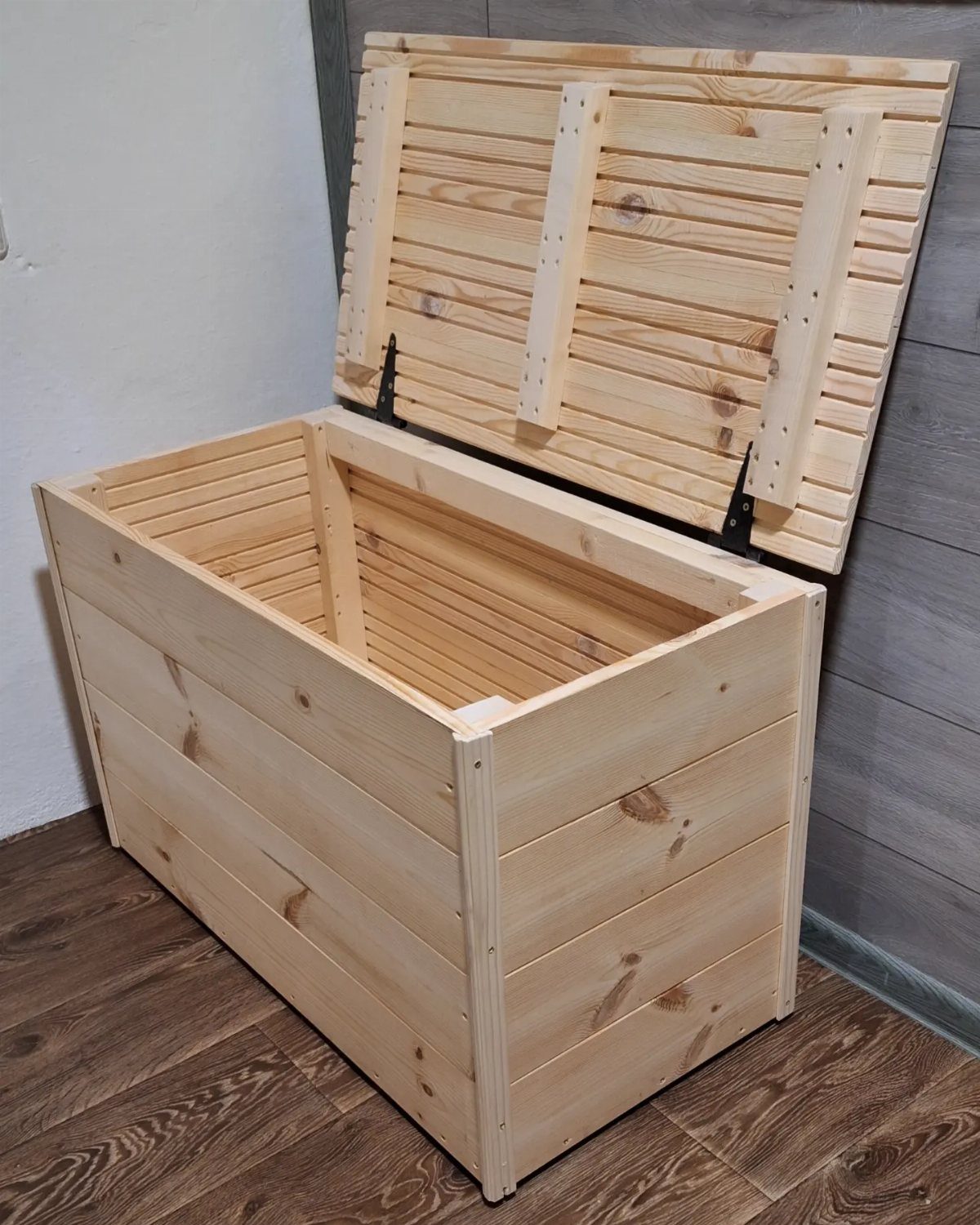 Wooden storage bin with an open lid made from light pine planks.