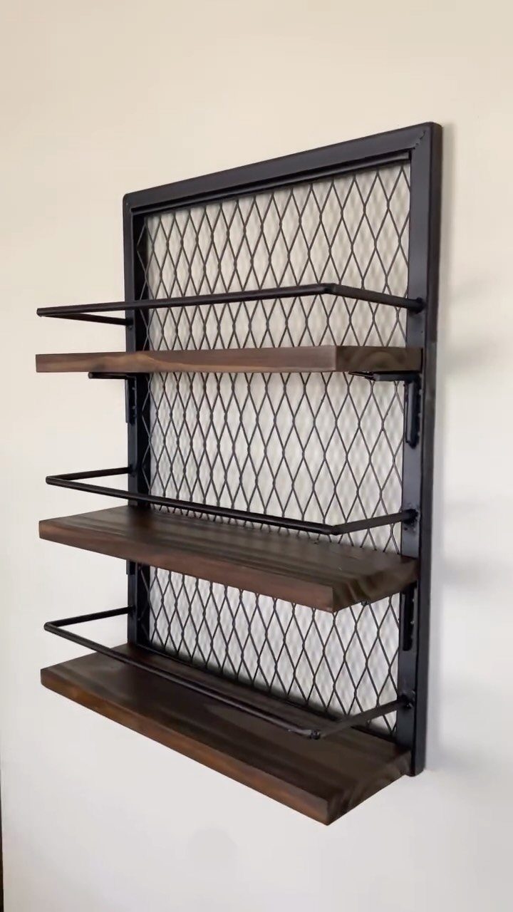 Wall-mounted industrial shelving unit with black metal mesh and dark wooden shelves.