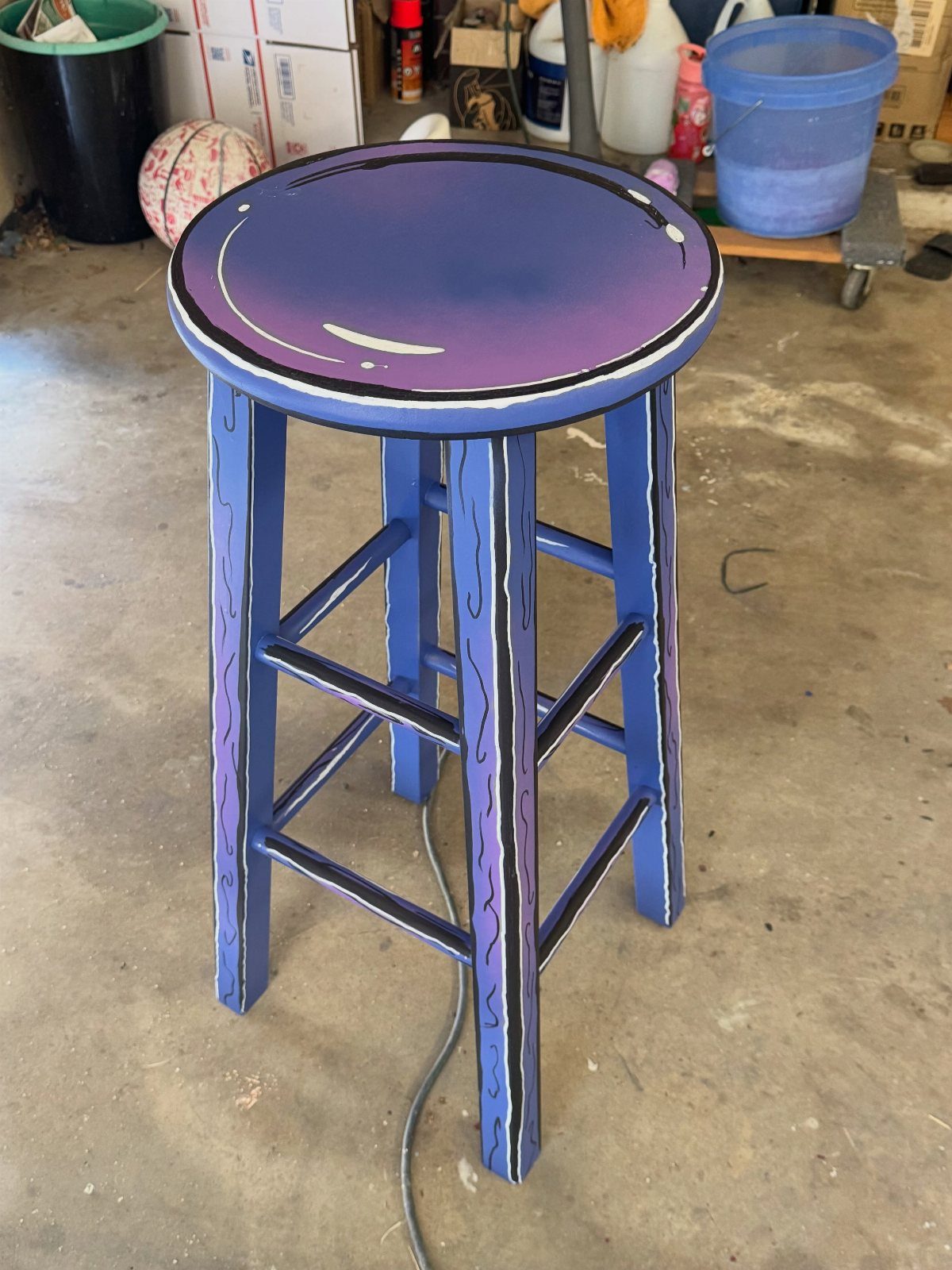 17 Wood Art Projects for Beginners and Weekend Makers 1 Cartoon style painted wooden stool with purple seat and blue legs in a garage.