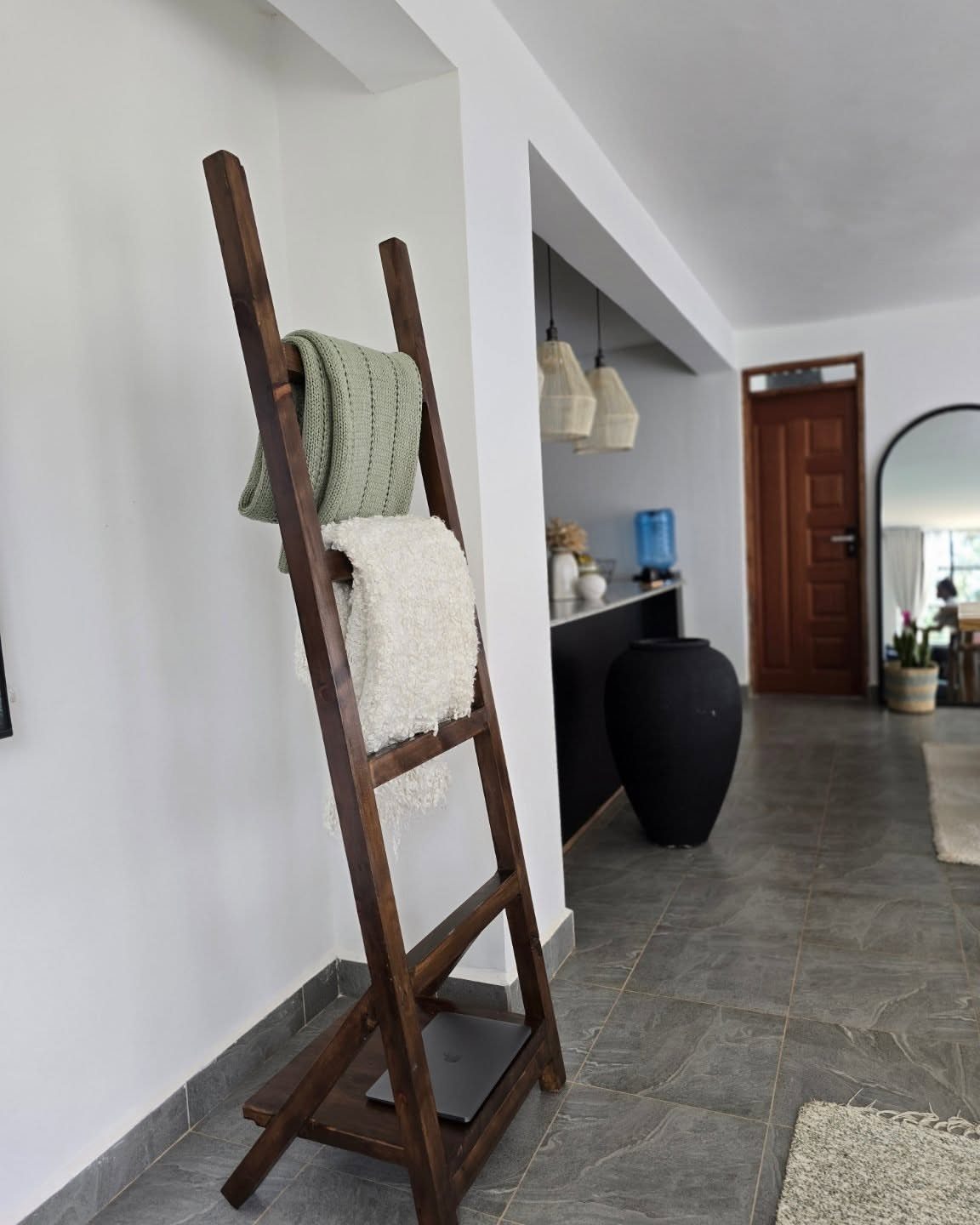 17 Wood Art Projects for Beginners and Weekend Makers 16 Wooden leaning ladder holding a green and white blanket against a white wall.