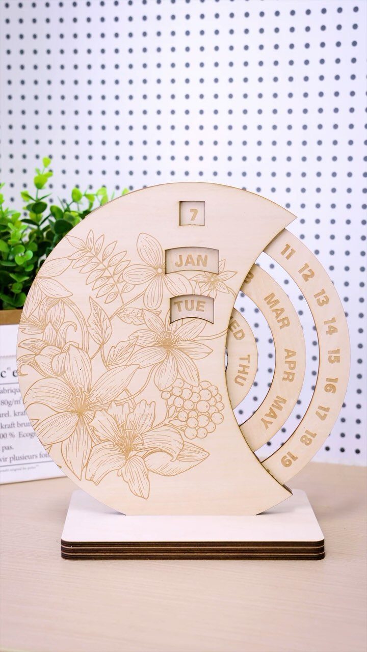 17 Wood Art Projects for Beginners and Weekend Makers 13 Wooden perpetual calendar with floral engravings and sliding date markers on a white surface.