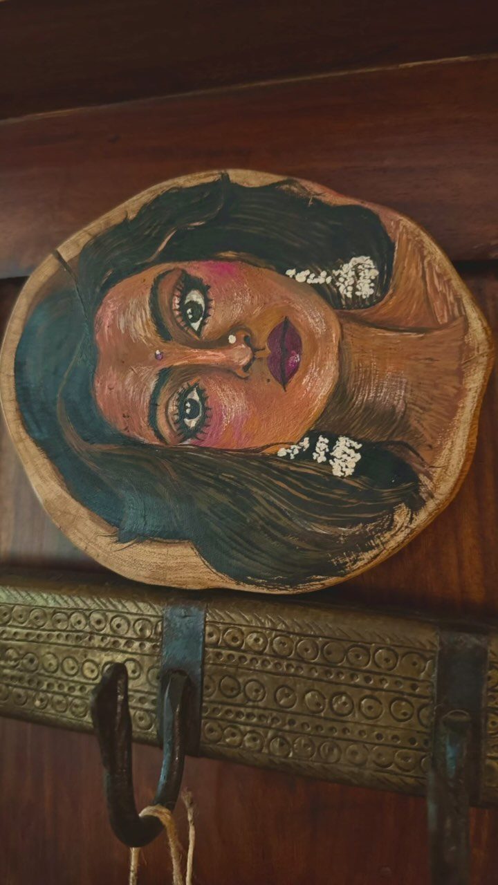 17 Wood Art Projects for Beginners and Weekend Makers 12 Painting of a woman's face on a natural oval wood slice decor piece.