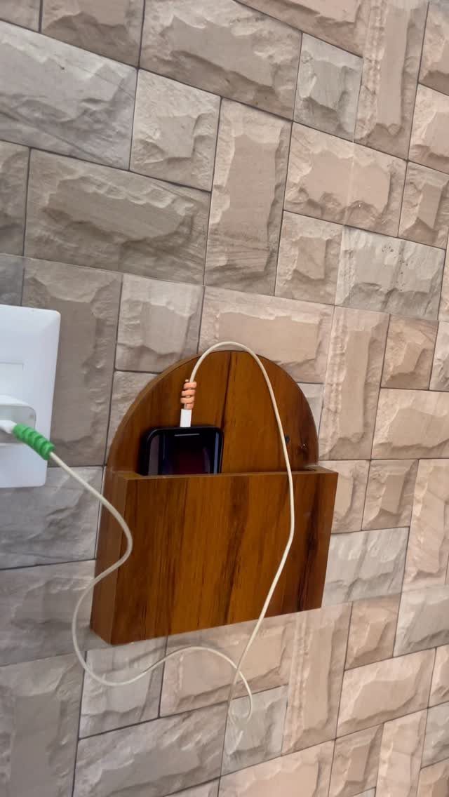 17 Wood Art Projects for Beginners and Weekend Makers 17 Wooden wall-mounted charging station holding a smartphone with a white charging cable.