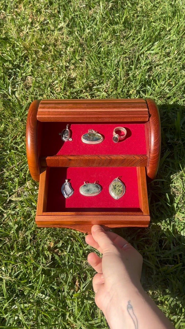 17 Wood Art Projects for Beginners and Weekend Makers 8 Wooden jewelry box with red velvet lining holding rings and pendants on green grass.