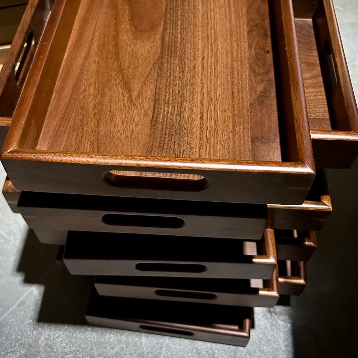 17 Wood Art Projects for Beginners and Weekend Makers 7 Stacked dark brown polished wooden serving trays with integrated rectangular side handles.
