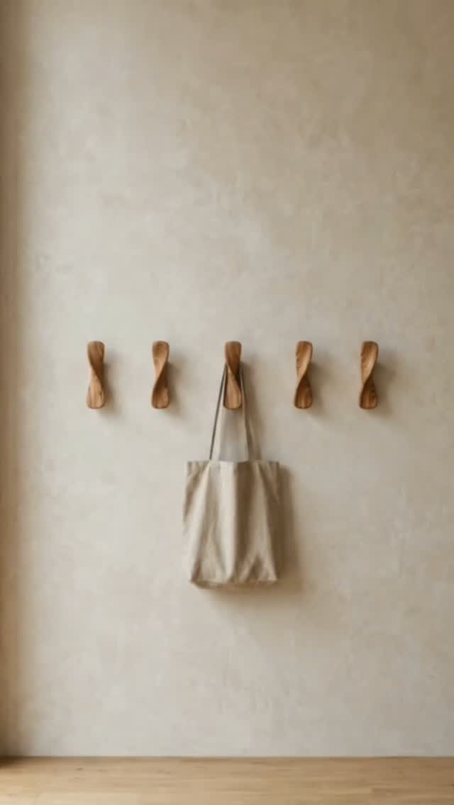 17 Wood Art Projects for Beginners and Weekend Makers 15 Six twisted wooden wall hooks on a beige wall with a canvas tote bag.