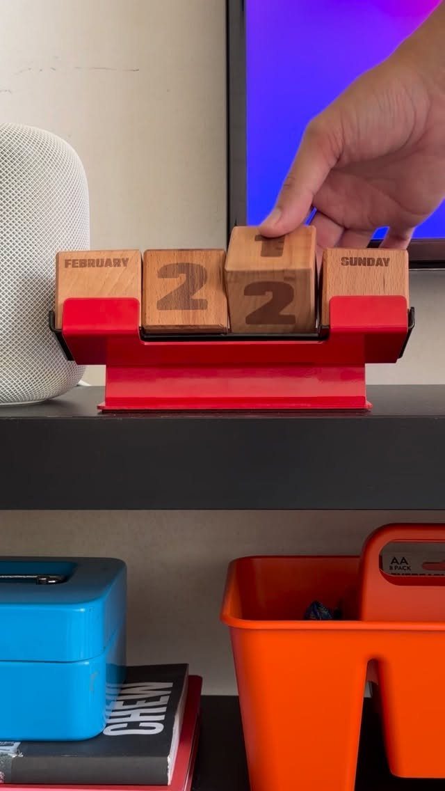 14 Wood Block Decorations for Every Season and Room 7 Wooden block perpetual calendar on a red stand being adjusted by a hand.