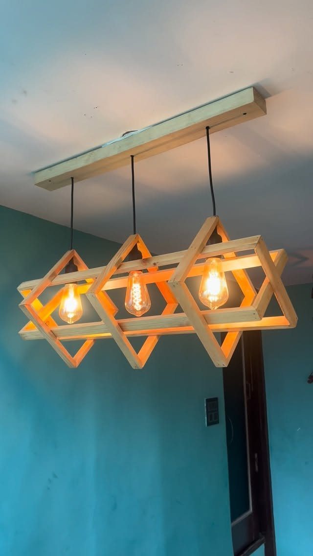 14 Wood Block Decorations for Every Season and Room 13 Geometric wooden block pendant light with three glowing bulbs hanging from a ceiling beam