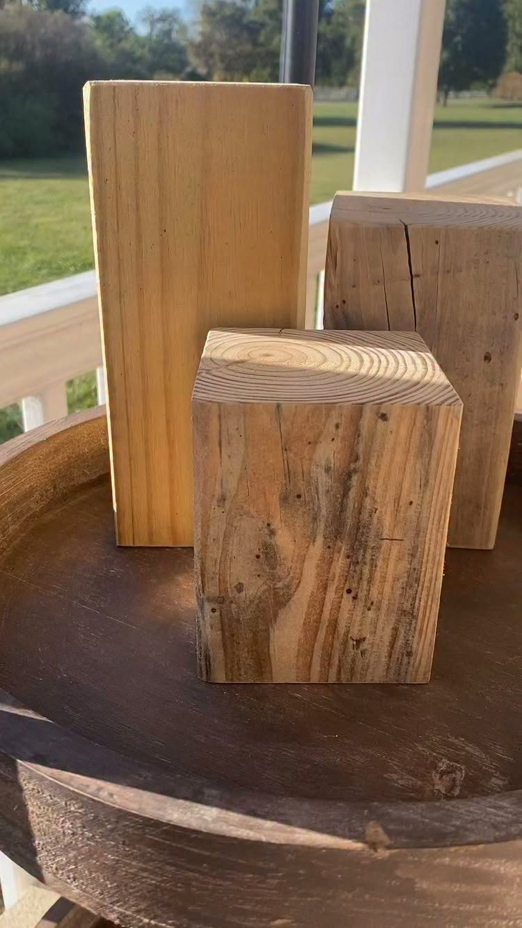 14 Wood Block Decorations for Every Season and Room 14 Three natural wood blocks of different heights on a rustic wooden surface outdoors.