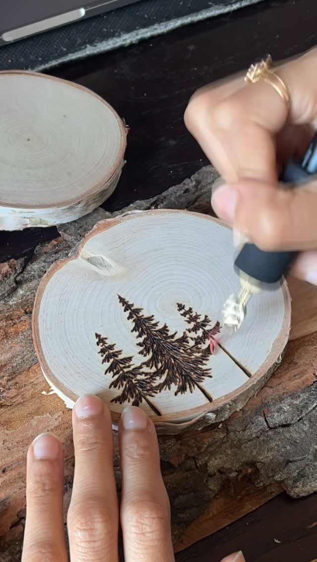 Wood Burned Pine Trees: 4 Ideas for Pyrography 2 Wood burning tool etching pine tree silhouettes onto a natural wood slice.
