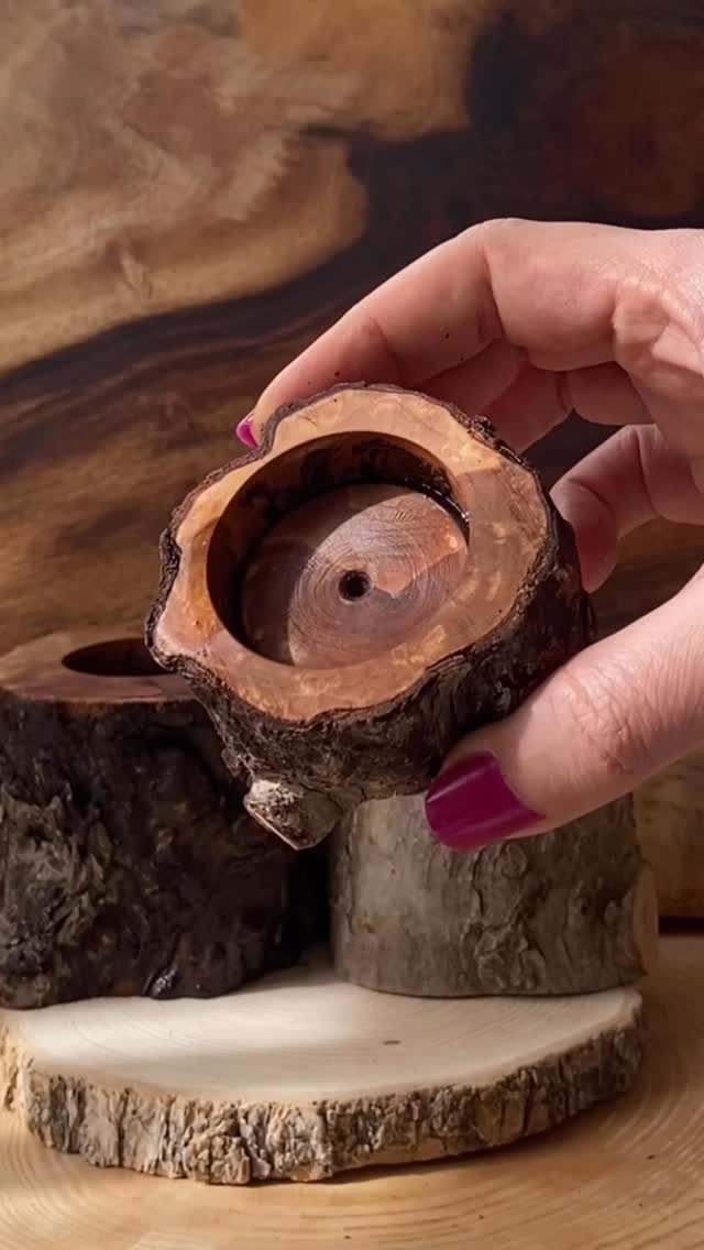 Rustic wooden candle holder made from a natural log slice held by a hand.
