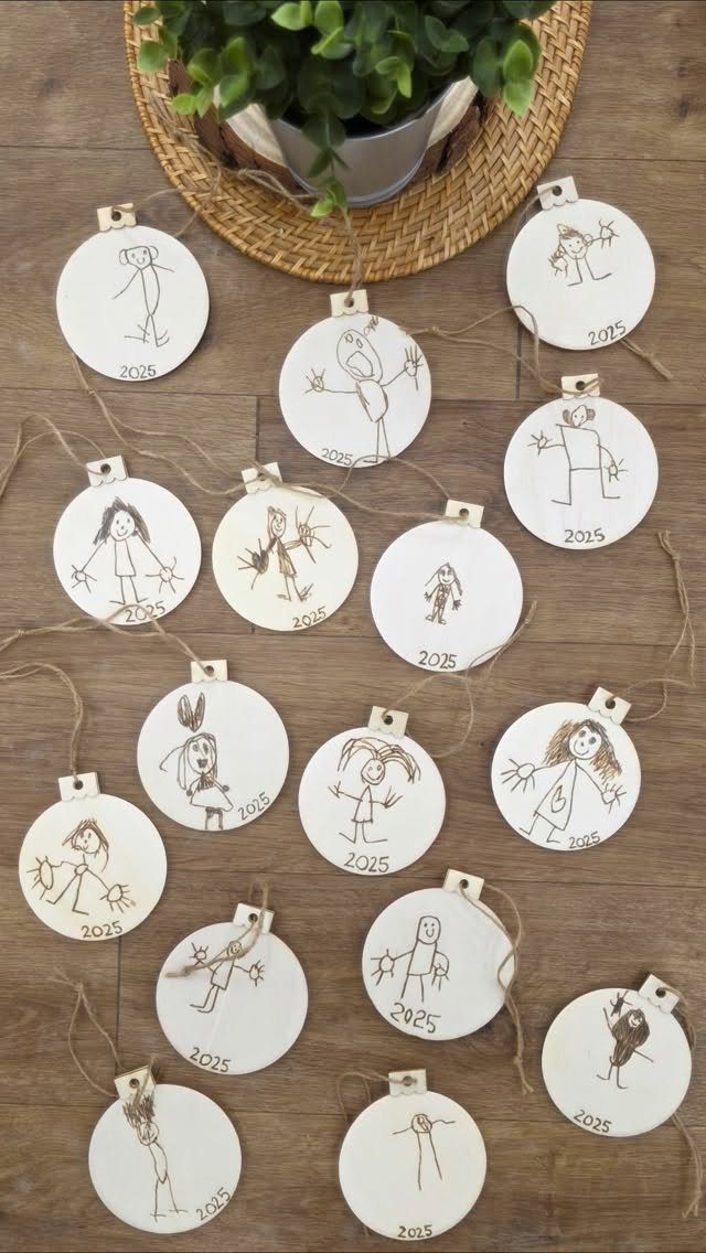 Circular wooden ornaments with wood-burned stick figure drawings and the year 2025.