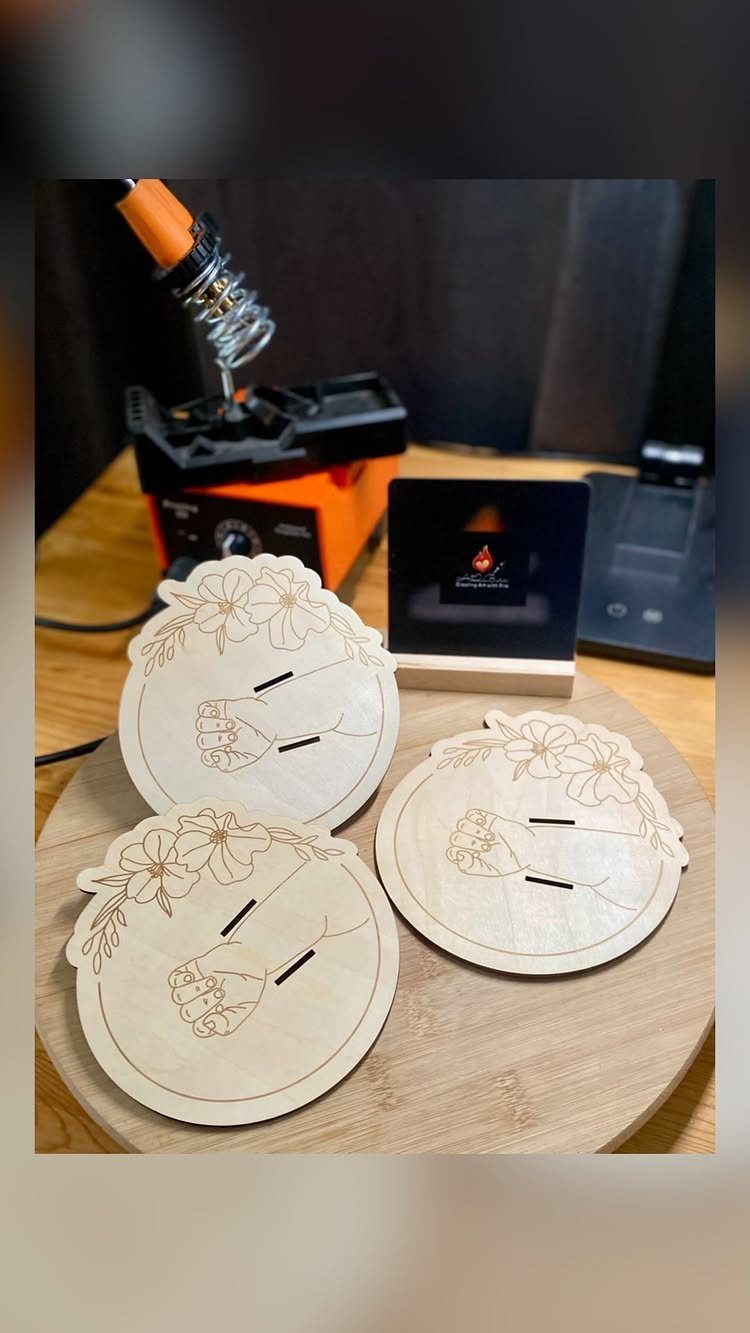 9 Wood Burning Images for Spoons, Plaques and Coasters 4 Circular wooden coasters with burned floral and hand designs on a wooden board.
