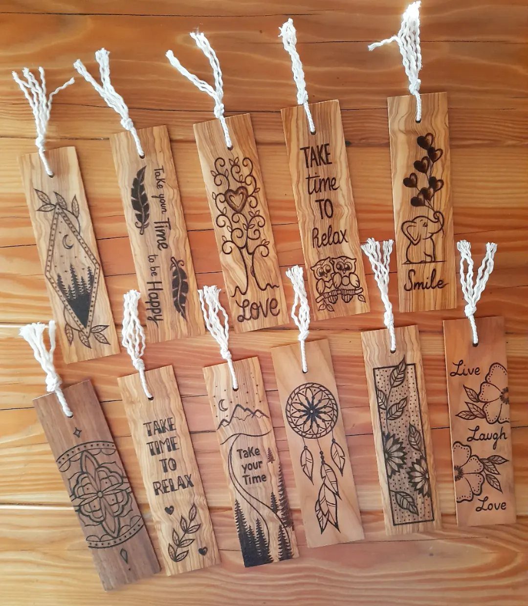 Wooden bookmarks with engraved patterns and quotes resting on a light wood background.