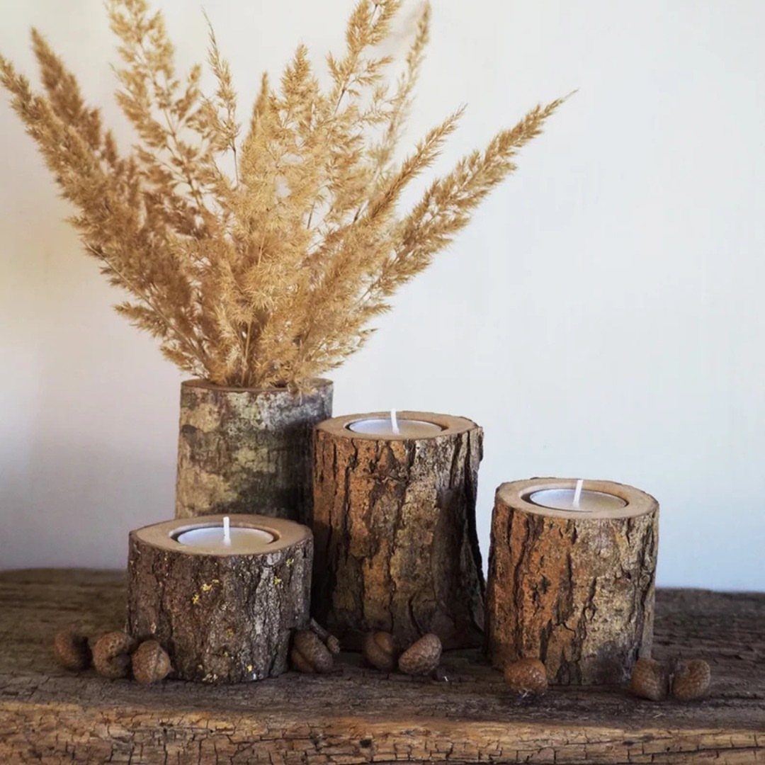 Rustic wooden candle holders made from log sections with white tea light candles.