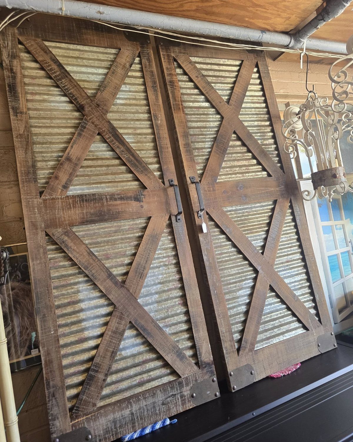 Rustic wooden barn doors with corrugated metal panels and black metal hardware.