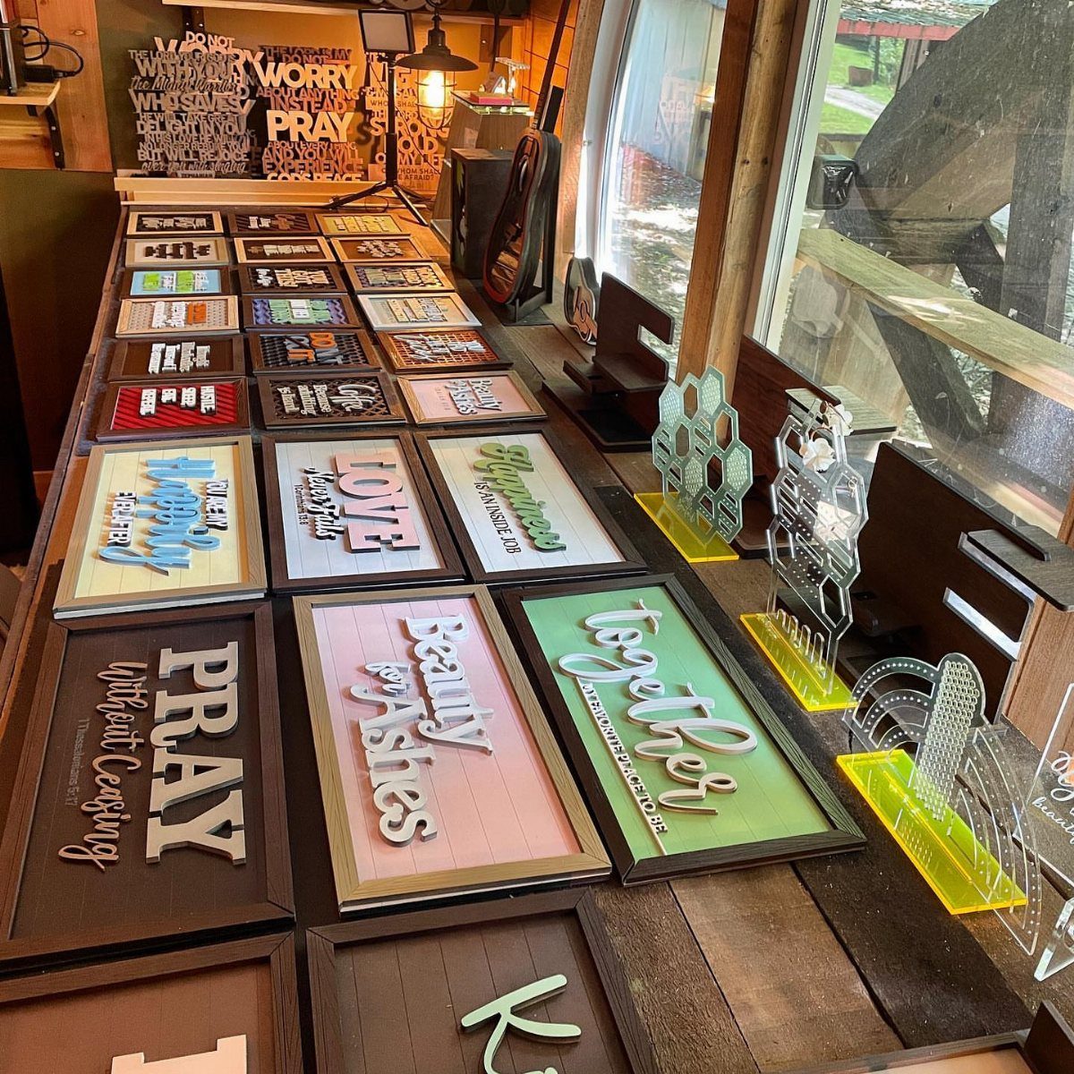 Wooden signs with inspirational messages and colorful backgrounds displayed on a wooden table.