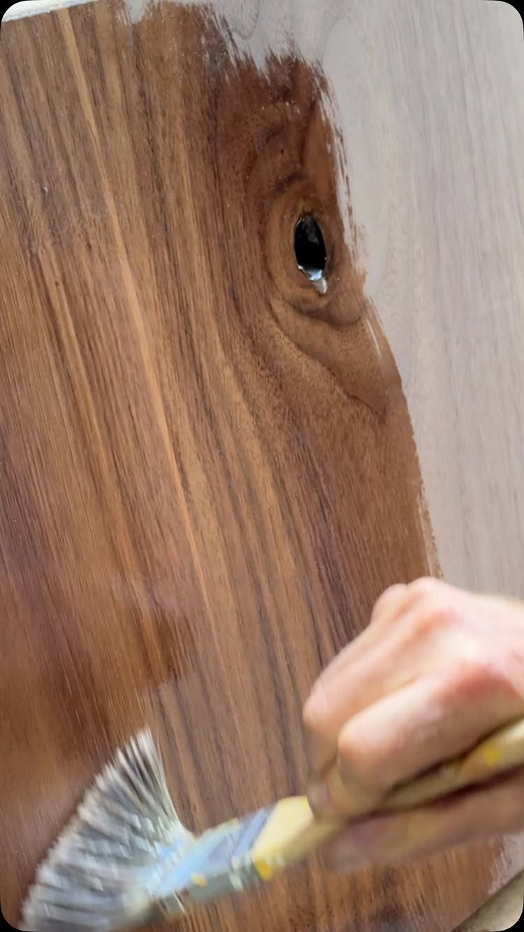 Wood Grain Stain: 8 Ideas for Color and Application 4 Hand using a brush to apply brown stain to a wooden board