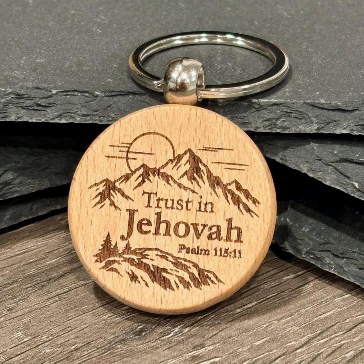 10 Wood Slice Crafts for Home Decor, Gifts and Games 9 Wood slice keychain with engraved mountains and biblical text on a slate background