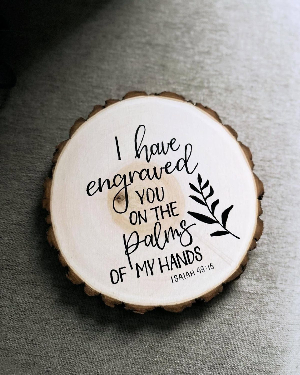 10 Wood Slice Crafts for Home Decor, Gifts and Games 4 Circular wood slice sign with engraved biblical text and a leaf illustration.