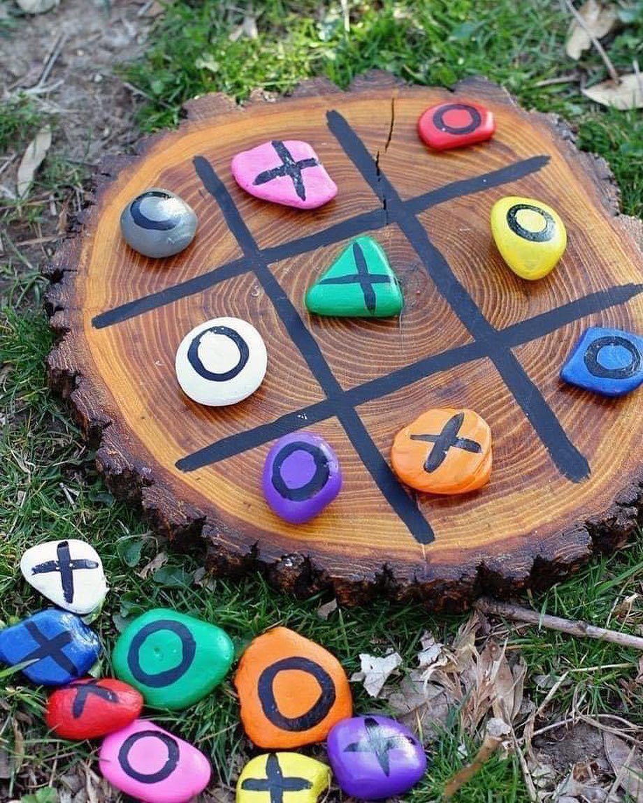 10 Wood Slice Crafts for Home Decor, Gifts and Games 2 Tic tac toe game on a wood slice with colorful painted stone markers.
