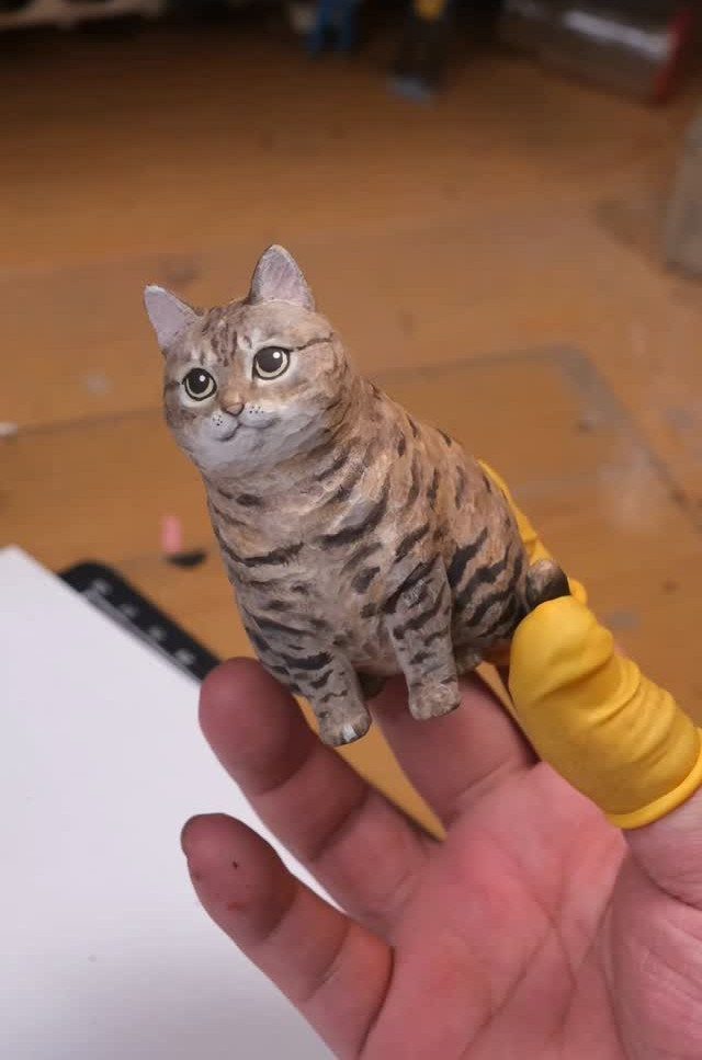 Wood Turned Cat Ideas: 5 Designs for the Lathe 4 Small hand-carved wooden tabby cat figurine held in a person's hand.