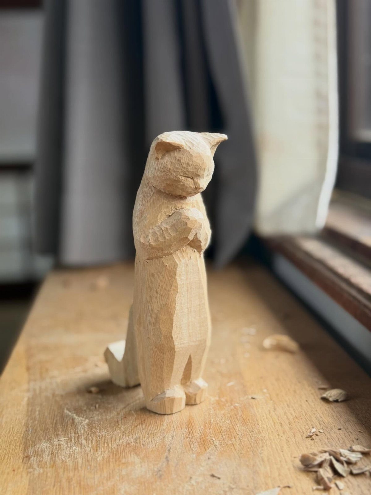 Wood Turned Cat Ideas: 5 Designs for the Lathe 5 Hand-carved wooden cat figurine standing on a workbench with wood shavings around it.