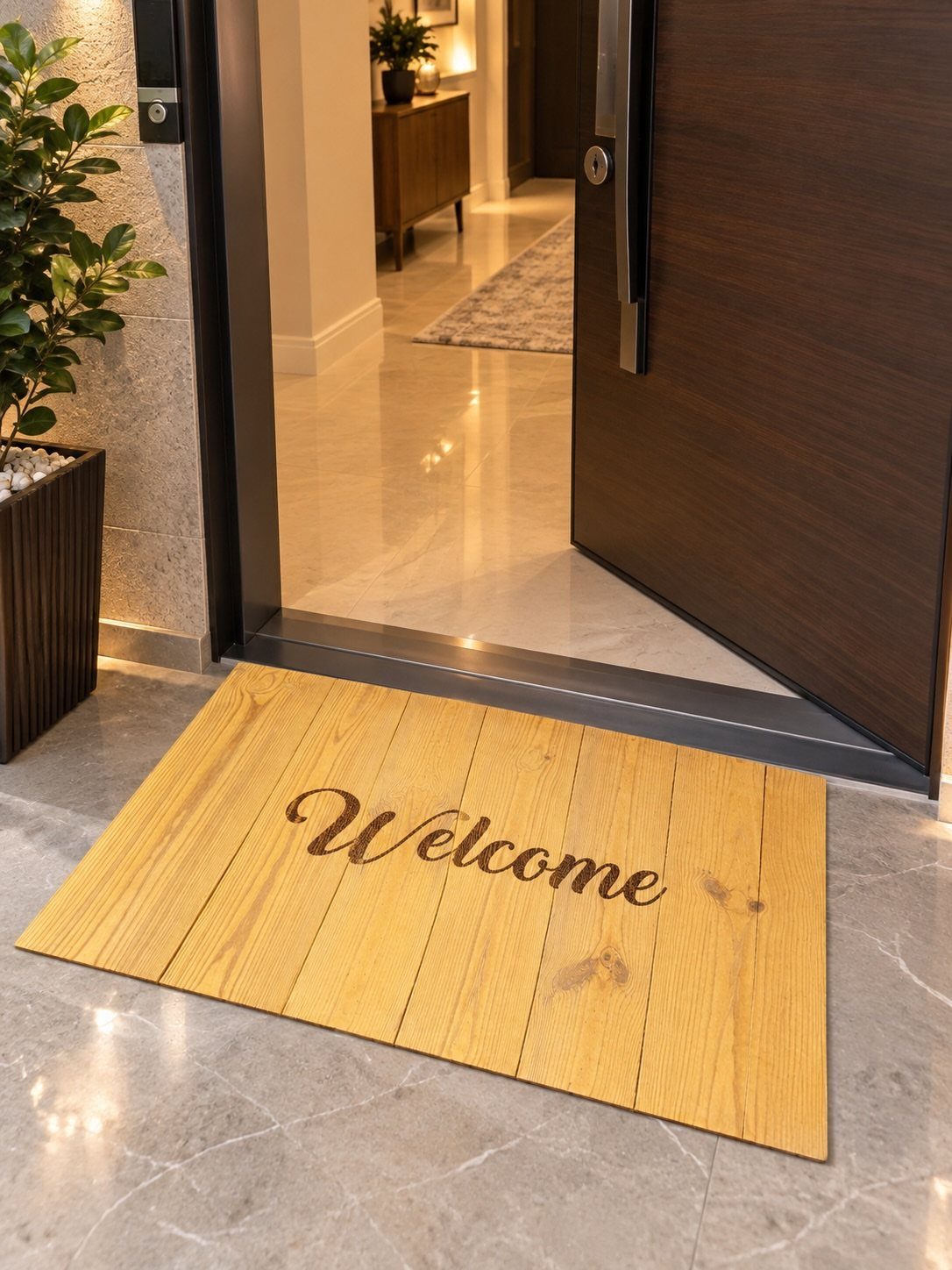 Wooden welcome mat with cursive text on a marble floor by an open door