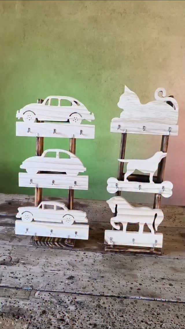 Wooden key holders with white car and animal silhouettes and metal hooks.