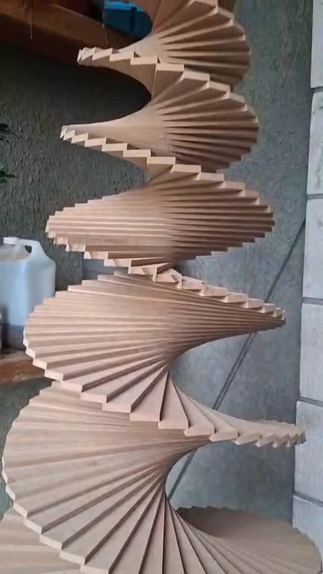 Spiral wooden sculpture made of slats shaped like a stylized Christmas tree.