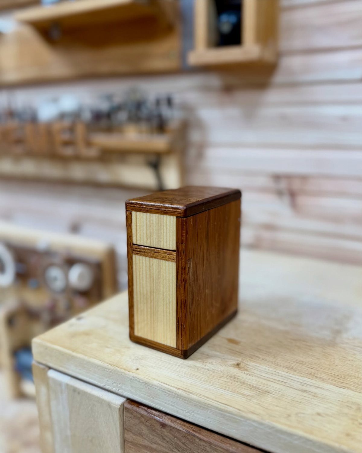 12 Woodworking Ideas to Make Money With Simple Builds 1 Small rectangular wooden box with light front panel on a workshop workbench.