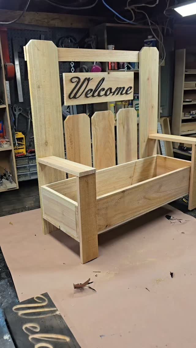 12 Woodworking Ideas to Make Money With Simple Builds 8 Wooden planter box shaped like a porch swing with a Welcome sign.