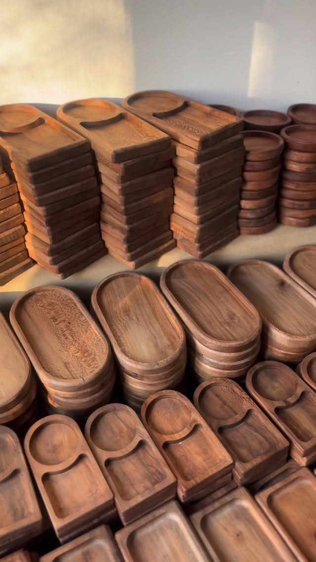 12 Woodworking Ideas to Make Money With Simple Builds 6 Handcrafted wooden serving trays in various shapes stacked on a display shelf.