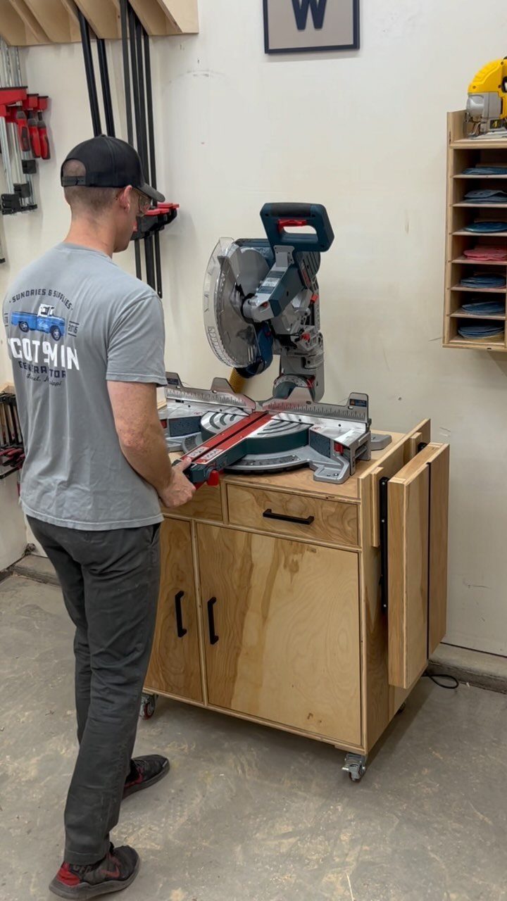 Man using a miter saw on a wooden mobile workbench in a workshop.