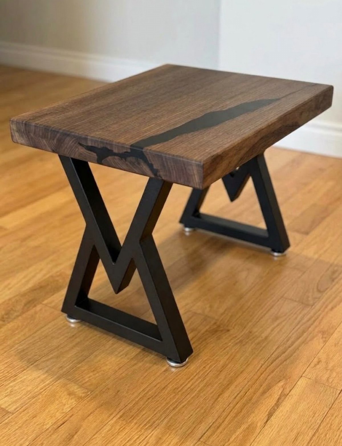 14 Woodworking Shop Projects for Every Skill Level 8 Side table with a dark wood resin river top and black metal legs.