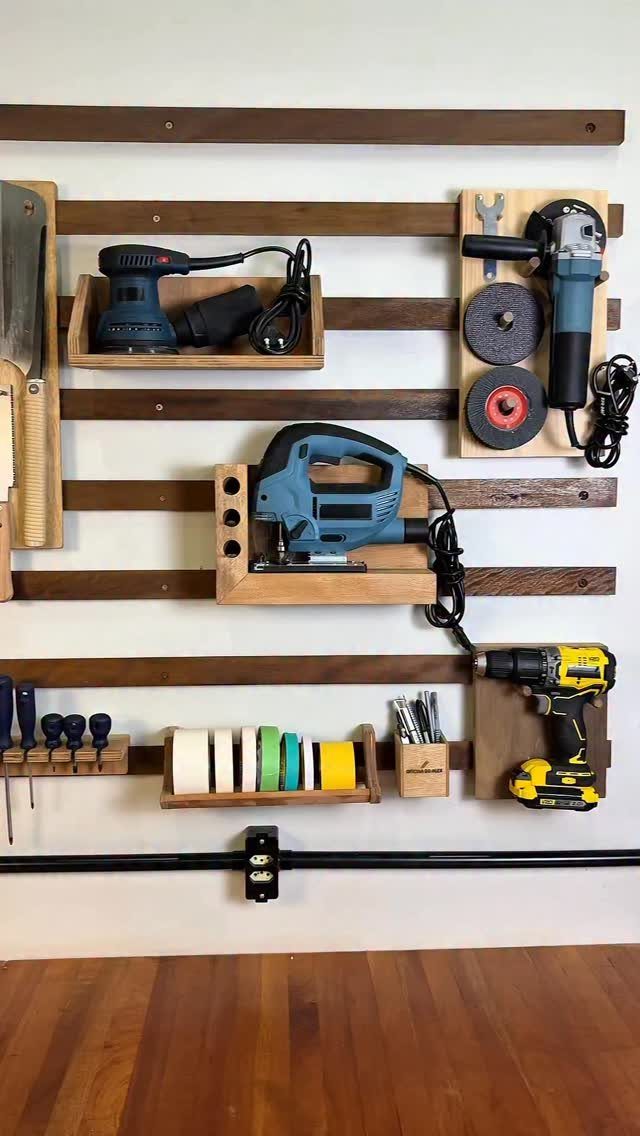 14 Woodworking Shop Projects for Every Skill Level 7 Wall-mounted tool organization system with wooden slats and custom holders for power tools.