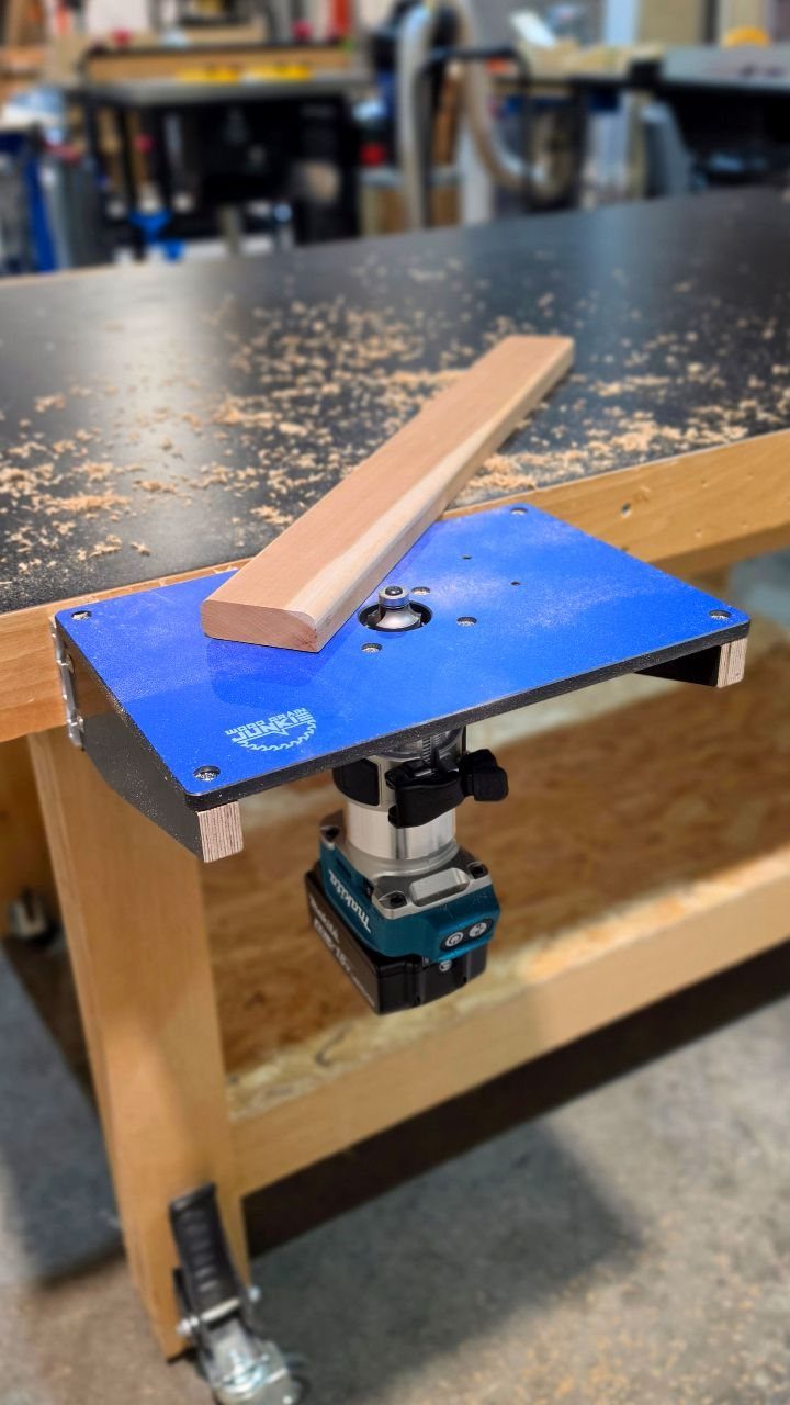 14 Woodworking Shop Projects for Every Skill Level 5 Blue router table top with a wooden piece on a workshop workbench