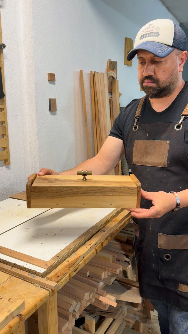 Woodworking Small Box Ideas: 5 Projects to Build 5 Man holding a small light-brown wooden storage box with a metal latch.