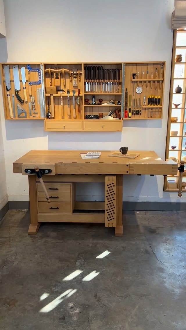 Woodworking Tool Cabinet Plans: 8 Storage Ideas 4 Wooden workbench with wall-mounted tool cabinets holding various woodworking hand tools.