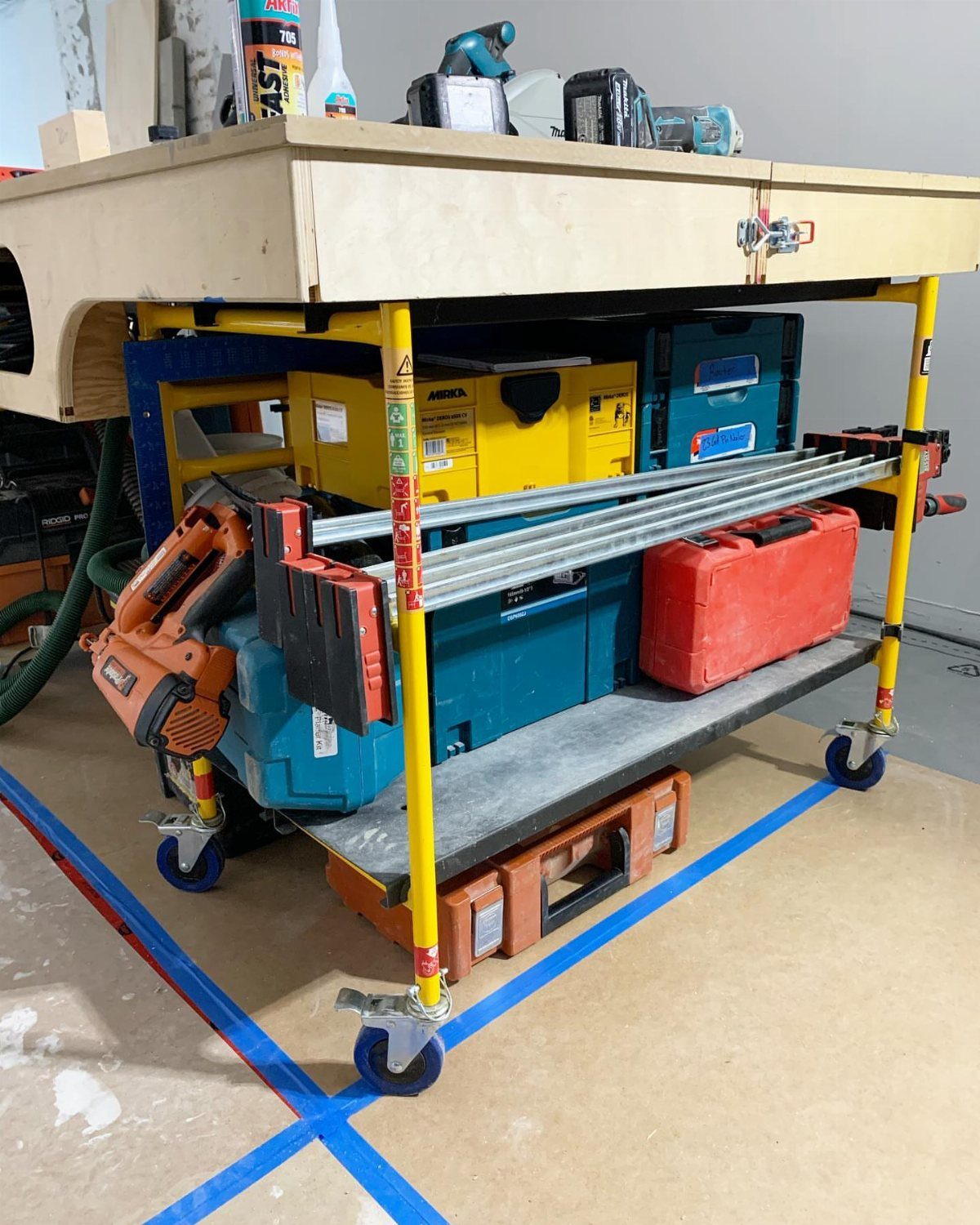 Workbench Tool Storage Ideas: 8 Setups for a Garage Shop 2 Mobile workbench with wooden top, yellow legs, caster wheels, and various power tools.