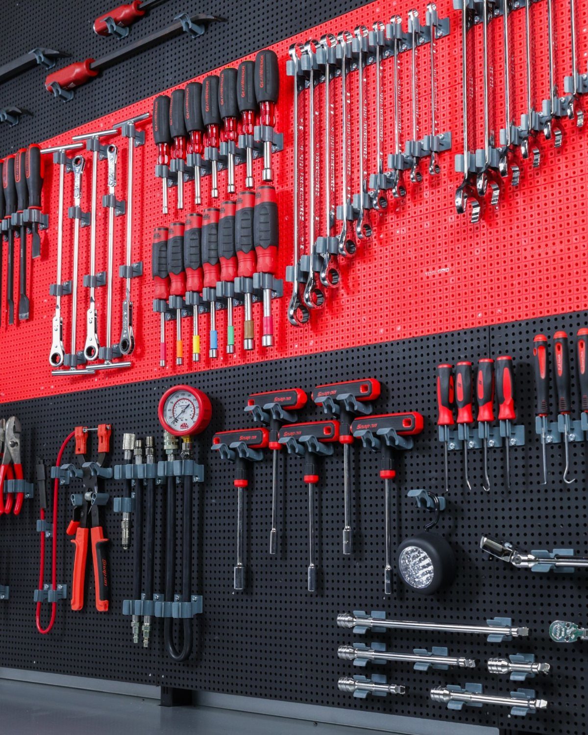 Workbench Tool Storage Ideas: 8 Setups for a Garage Shop 3 Organized hand tools on a red and black pegboard with grey tool holders.