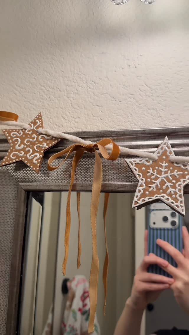 Brown star-shaped clay ornaments with white patterns on a white rope garland.
