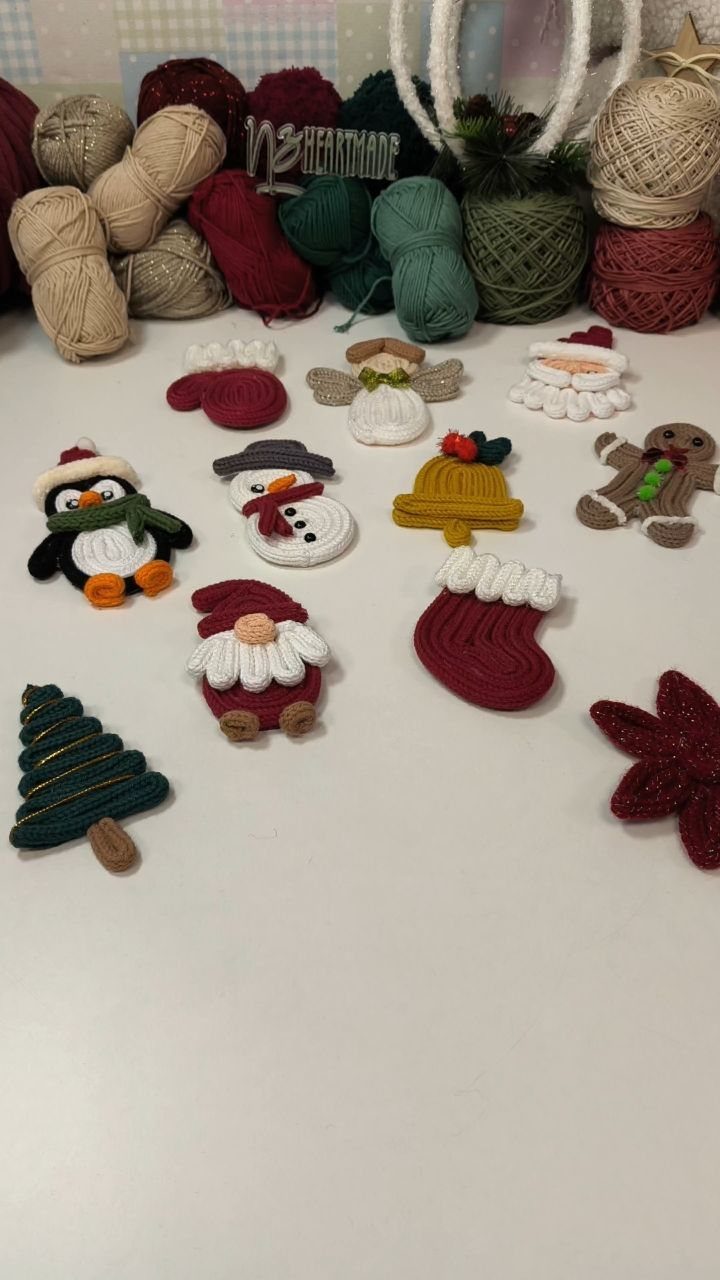 Crocheted Christmas figures and colorful yarn balls on a white tabletop.